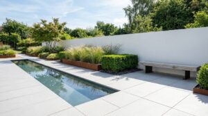 Contemporary garden with porcelain paving, a still water rill and corten steel planters